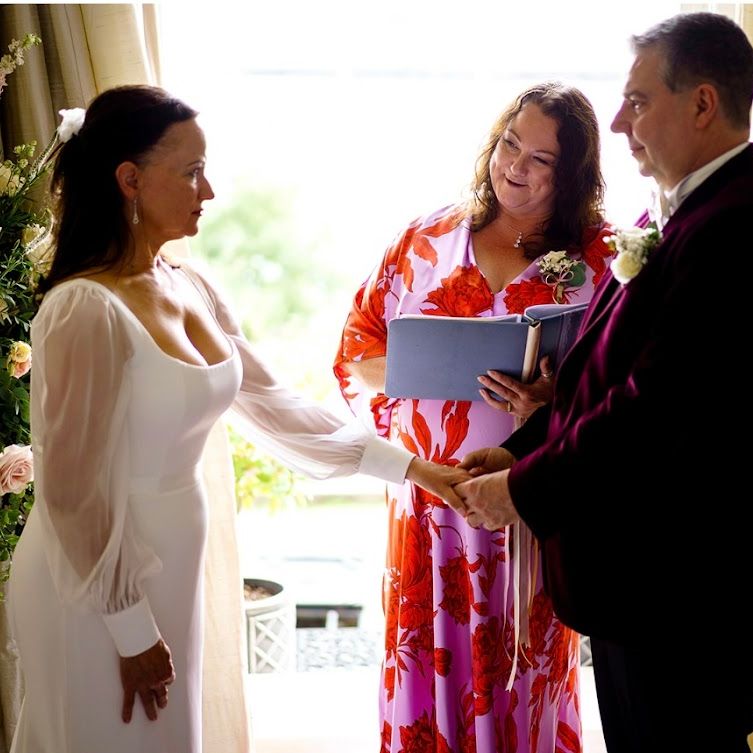 Sara smiling at a Bride as she holds her new husbands hand